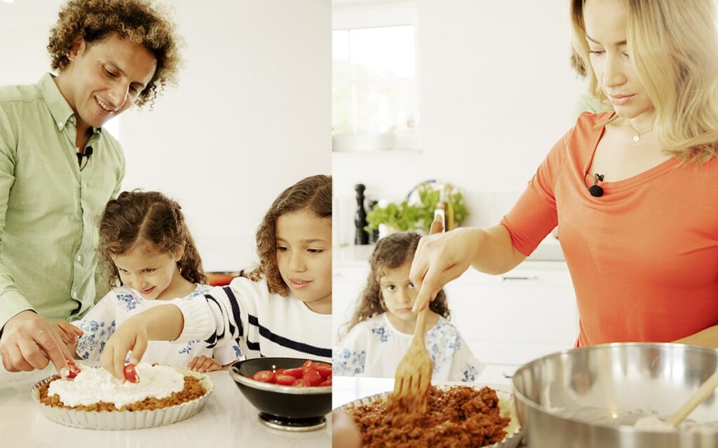 Barnfamilj lagar vego mat tillsammans i kök.