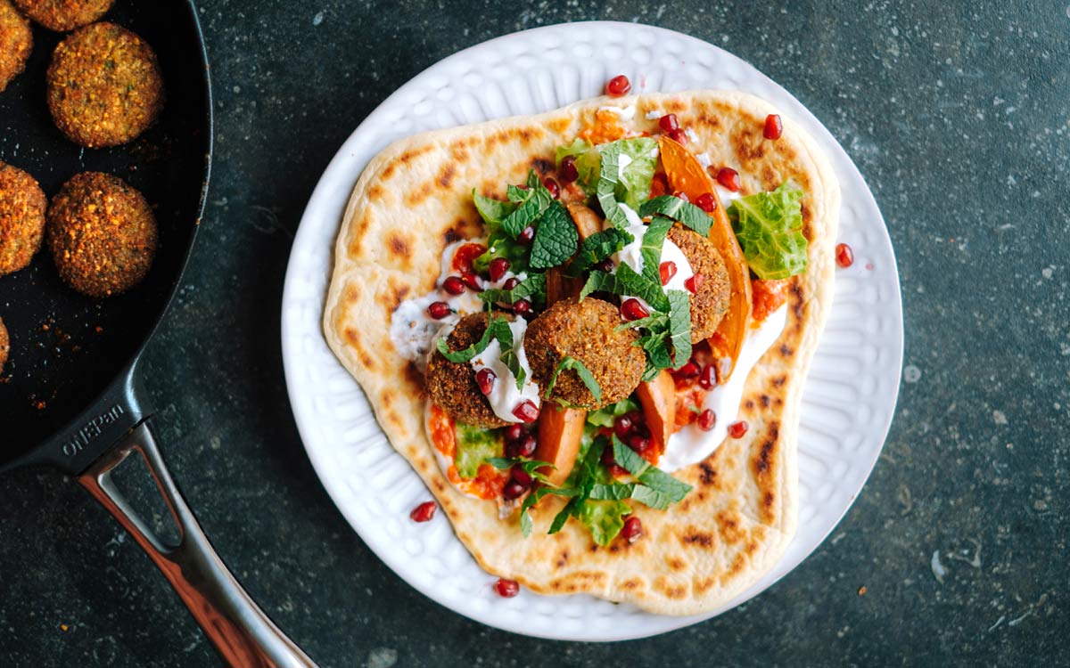 Krispig falafel i stekpannebröd med sallad, sås och granäpple - Anamma