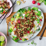 Fat med asiatisk nudelsallad med grönsaker, vegetarisk hoisinfärs och hackade jordnötter.