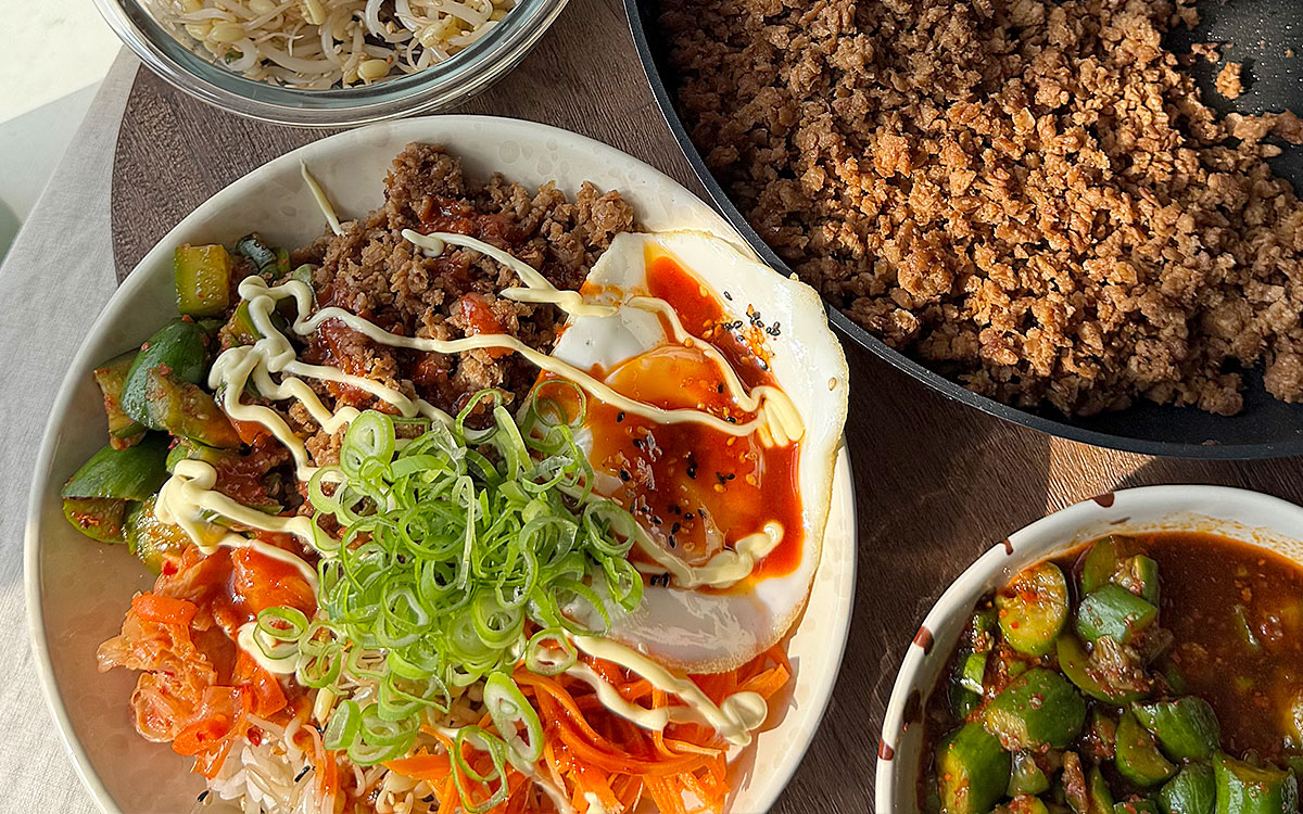 Skål med bibimbap gjord på Anammas formbara vegofärs toppad med picklade morötter, böngroddar, stekt ägg och kimchi.